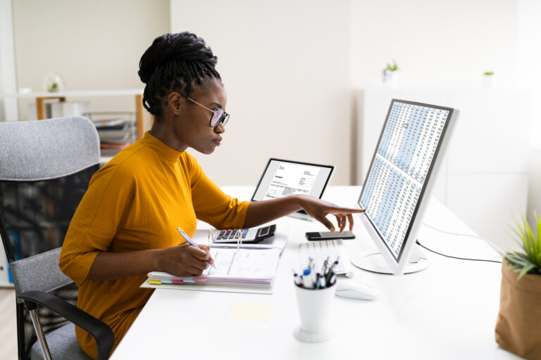 Nonprofit case manager reviewing reports on laptop, streamlining operations with integrated digital tools.