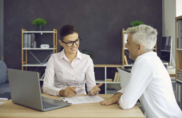 Program manager meets with a client at a laptop, showcasing case management and client documentation software in use
